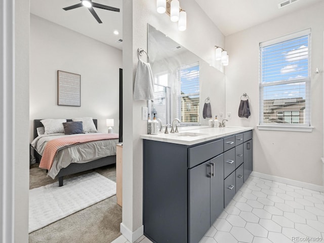 ensuite bathroom featuring ceiling fan, connected bathroom, double vanity, and a sink