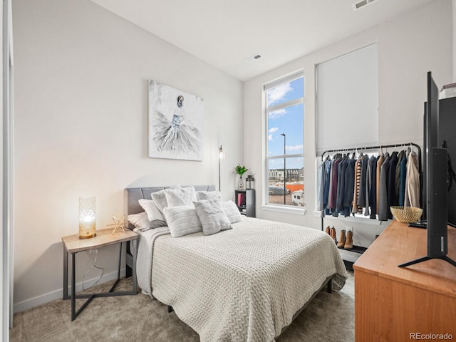 carpeted bedroom featuring visible vents and baseboards