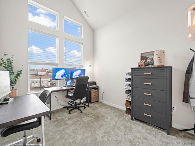 office space with light colored carpet, baseboards, high vaulted ceiling, and visible vents