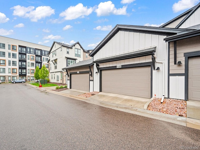 exterior space with board and batten siding, driveway, and a garage