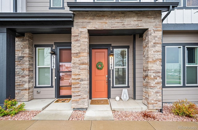 property entrance featuring stone siding and board and batten siding