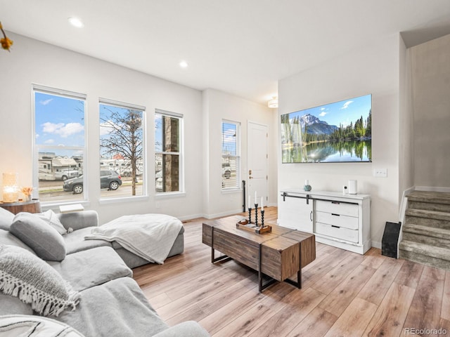 living area with stairway, recessed lighting, baseboards, and light wood-style floors
