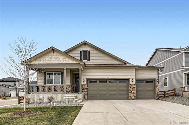 235 Yellowtail St, Bennett, CO 80102 - view of front facade featuring stone siding, covered porch, a garage, fence, and concrete driveway