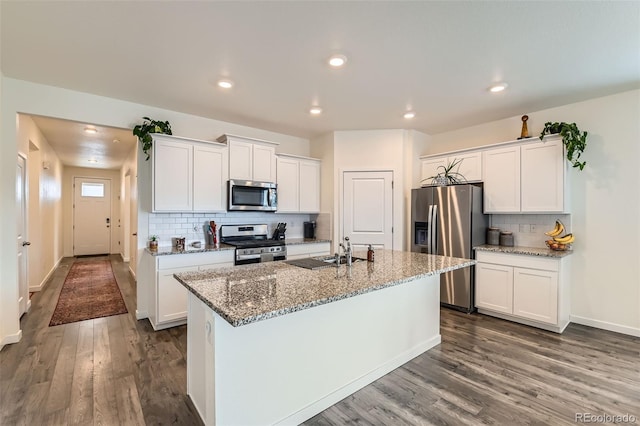 235 Yellowtail St, Bennett, CO 80102 - kitchen with dark wood-style flooring, light stone countertops, white cabinetry, and stainless steel appliances