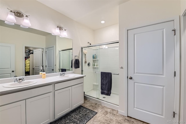 235 Yellowtail St, Bennett, CO 80102 - bathroom featuring a sink, a walk in closet, a shower stall, and double vanity