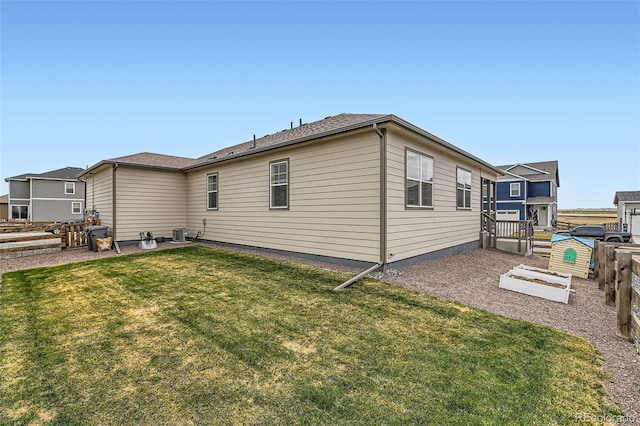 235 Yellowtail St, Bennett, CO 80102 - back of property with central AC unit, fence, and a lawn