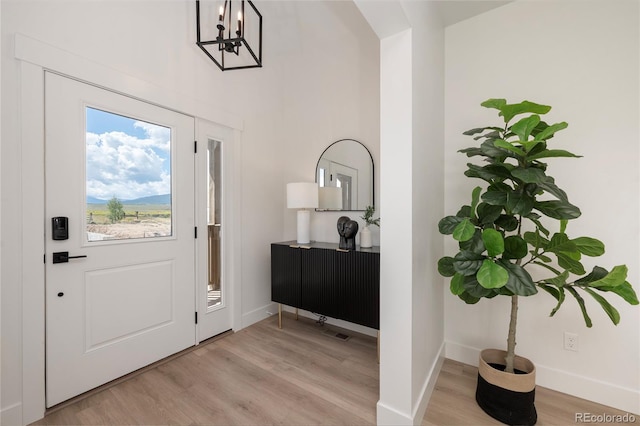 2101 Lupine Ln, Tabernash, CO 80478 - foyer featuring light wood finished floors, baseboards, a chandelier, and a high ceiling