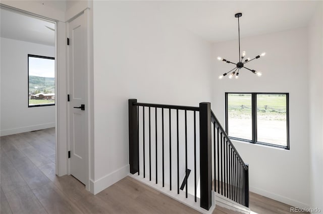 2101 Lupine Ln, Tabernash, CO 80478 - staircase with healthy amount of natural light, a chandelier, wood finished floors, and baseboards