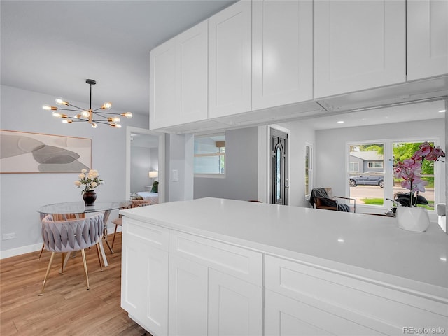 5152 Bryant St, Denver, CO 80221 - kitchen with a chandelier, white cabinetry, light wood-style floors, and light countertops