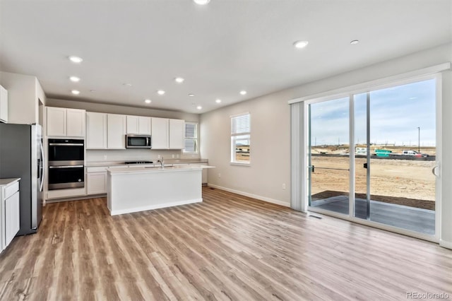 1397 Brookfield Pl, Erie, CO 80026 - kitchen with light wood-type flooring, a sink, baseboards, stainless steel appliances, and white cabinetry