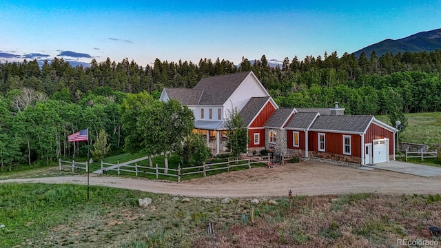 16202 County Road 327, Buena Vista, CO 81211 - view of front facade with concrete driveway, a garage, a wooded view, and board and batten siding