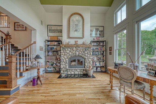16202 County Road 327, Buena Vista, CO 81211 - living room with wood finished floors, stairway, a stone fireplace, and a towering ceiling