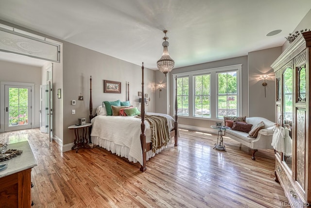 16202 County Road 327, Buena Vista, CO 81211 - bedroom featuring multiple windows, light wood finished floors, a chandelier, and access to outside