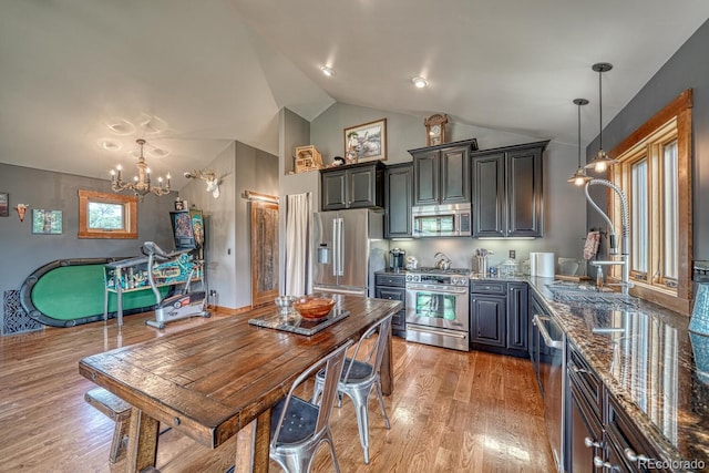 16202 County Road 327, Buena Vista, CO 81211 - kitchen featuring high quality appliances, a chandelier, dark stone counters, light wood-style floors, and decorative light fixtures