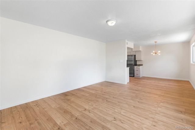 9320 Fir Dr, Thornton, CO 80229 - unfurnished living room featuring a chandelier and light wood-style flooring
