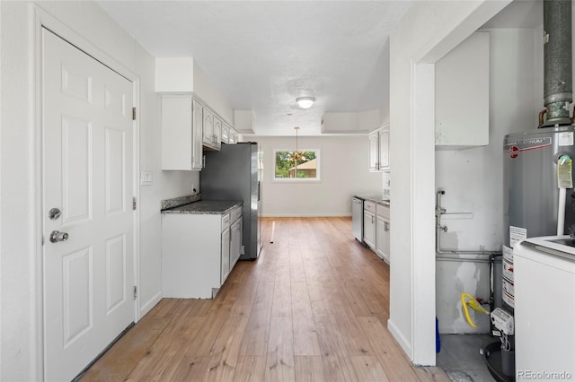 9320 Fir Dr, Thornton, CO 80229 - kitchen featuring appliances with stainless steel finishes, light wood finished floors, white cabinets, and gas water heater