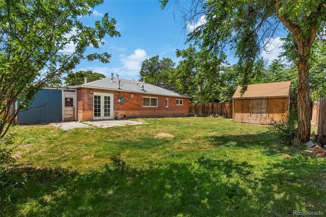 9320 Fir Dr, Thornton, CO 80229 - rear view of property featuring french doors, a storage shed, a fenced backyard, and brick siding