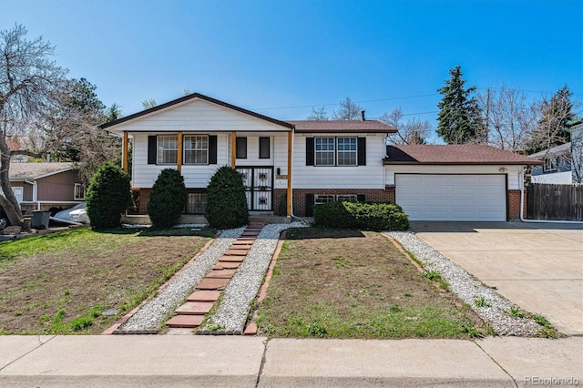 13472 W Dakota Ave, Lakewood, CO 80228 - raised ranch with brick siding, an attached garage, fence, and driveway