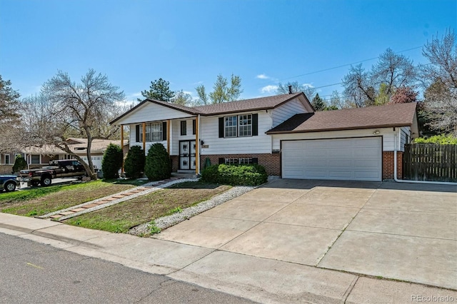 13472 W Dakota Ave, Lakewood, CO 80228 - raised ranch with driveway, brick siding, fence, a front lawn, and an attached garage