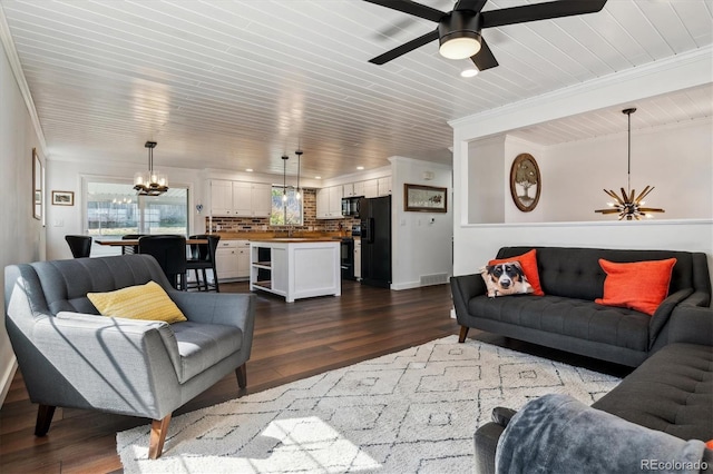 13472 W Dakota Ave, Lakewood, CO 80228 - living room with visible vents, crown molding, baseboards, ceiling fan with notable chandelier, and dark wood-type flooring