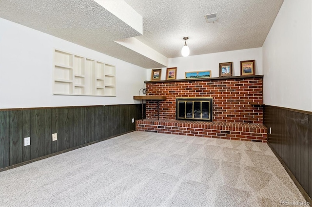 13472 W Dakota Ave, Lakewood, CO 80228 - below grade area featuring a brick fireplace, wooden walls, a textured ceiling, a wainscoted wall, and carpet flooring