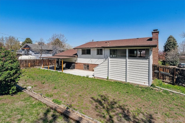 13472 W Dakota Ave, Lakewood, CO 80228 - rear view of house featuring a lawn, a patio, a chimney, and a fenced backyard