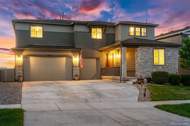 view of front facade with a garage, driveway, and stone siding