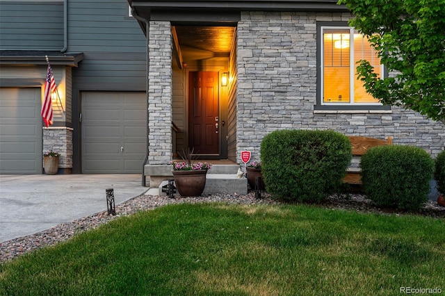 entrance to property with concrete driveway and a lawn