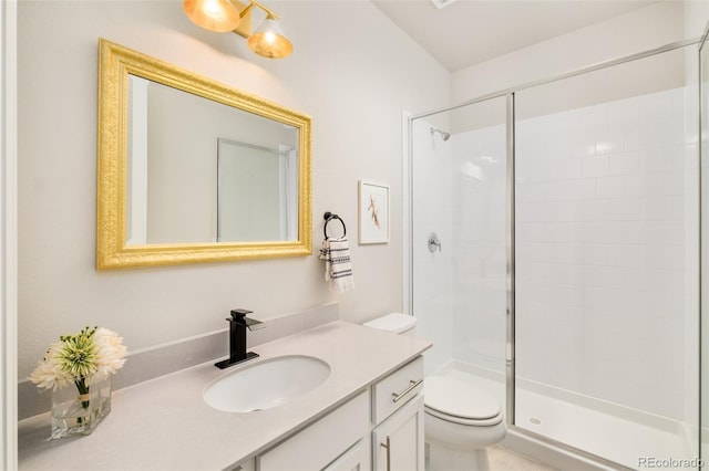 bathroom with vanity, a shower stall, and toilet