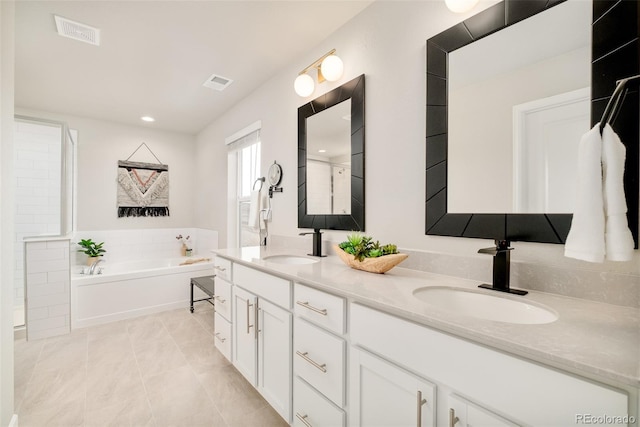 full bath featuring a garden tub, visible vents, and a sink