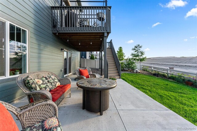 view of patio / terrace featuring fence and stairway