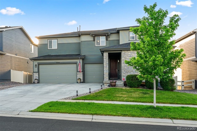 view of front of home with a front yard, fence, a garage, stone siding, and driveway