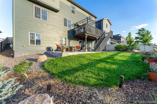 rear view of house with a yard, a patio, stairway, fence, and a deck