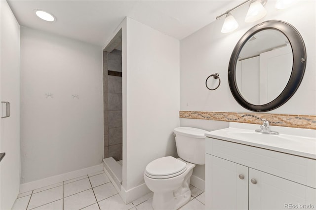 bathroom with tile patterned floors, vanity, toilet, and tiled shower