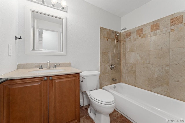 full bathroom with tile patterned flooring, tiled shower / bath combo, toilet, and vanity