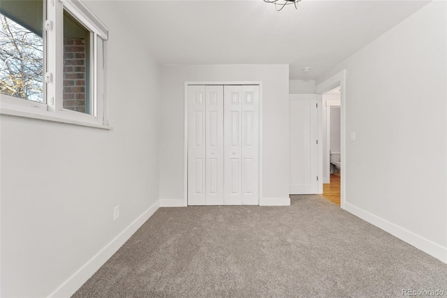 unfurnished bedroom featuring carpet flooring and a closet