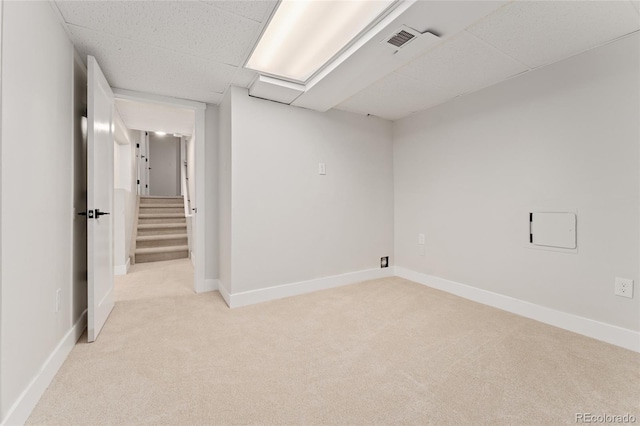 unfurnished room with a drop ceiling and light colored carpet