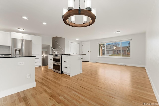 kitchen featuring a center island, light hardwood / wood-style floors, white cabinetry, and appliances with stainless steel finishes