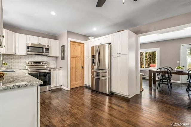 9092 Gray Ln, Conifer, CO 80433 - kitchen with stainless steel appliances, a sink, a ceiling fan, light stone countertops, and white cabinetry