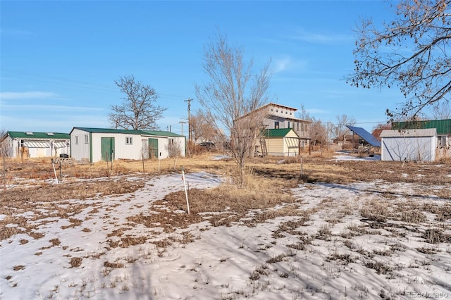 yard covered in snow with an outbuilding