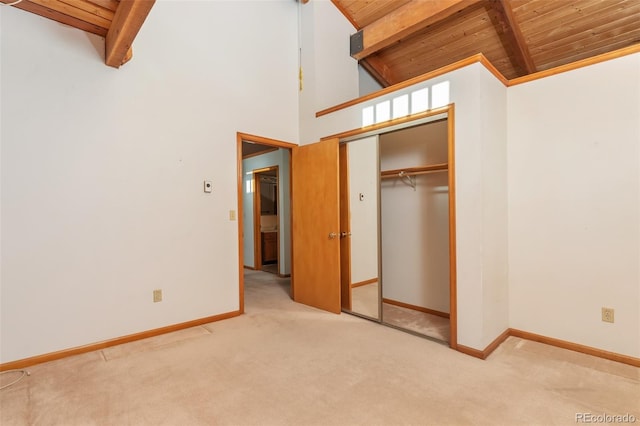 unfurnished bedroom featuring carpet floors, wood ceiling, and beam ceiling