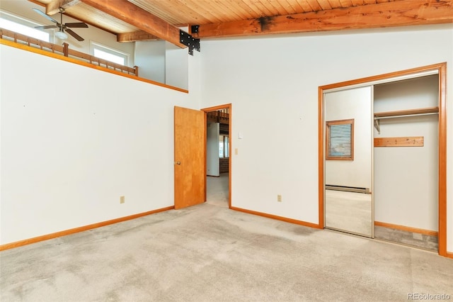 unfurnished bedroom featuring wooden ceiling, carpet, baseboards, and beam ceiling