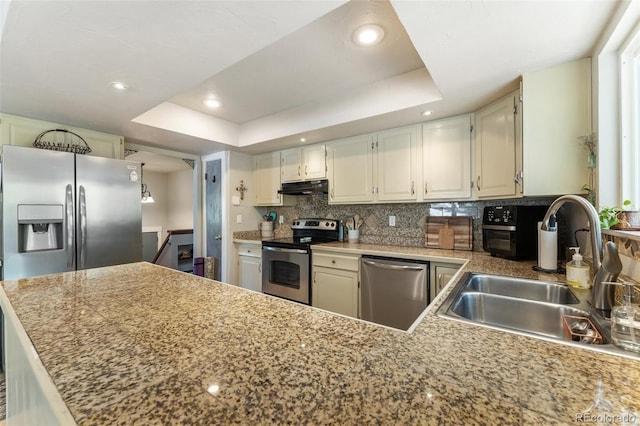 6170 Castlewood Ln, Colorado Springs, CO 80918 - kitchen with appliances with stainless steel finishes, backsplash, under cabinet range hood, a raised ceiling, and recessed lighting