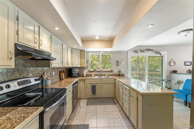 6170 Castlewood Ln, Colorado Springs, CO 80918 - kitchen featuring appliances with stainless steel finishes, under cabinet range hood, a peninsula, tasteful backsplash, and light tile patterned floors