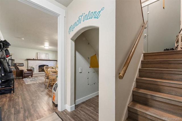 6170 Castlewood Ln, Colorado Springs, CO 80918 - stairway with a brick fireplace, wood finished floors, and arched walkways