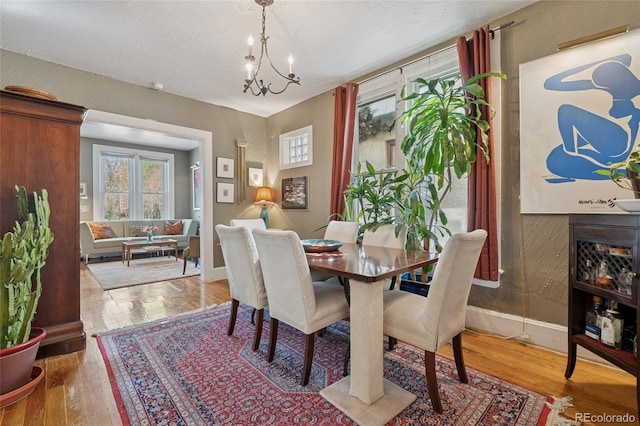 34 W Maple Ave, Denver, CO 80223 - dining area featuring wood finished floors and a chandelier