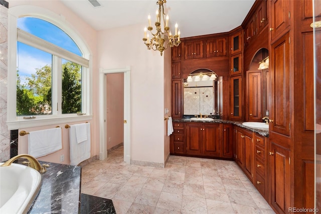 6901 E 12th Ave, Denver, CO 80220 - bathroom featuring double vanity, a chandelier, a tub to relax in, and baseboards