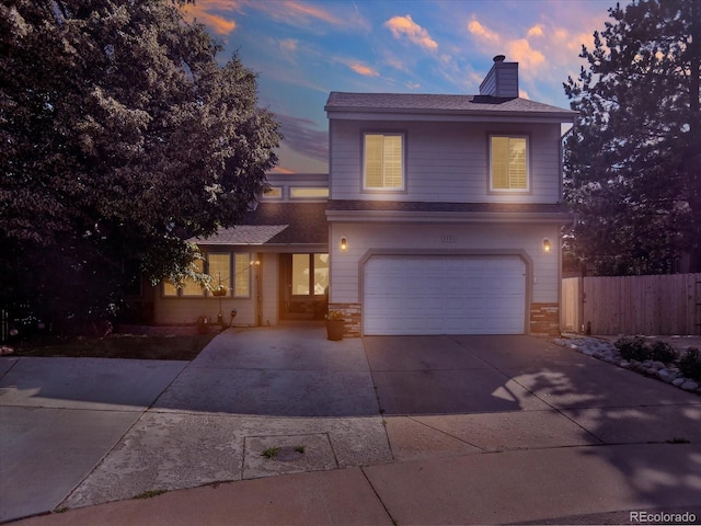 3596 S Telluride Way, Aurora, CO 80013 - view of front of home featuring an attached garage, a chimney, driveway, and a shingled roof
