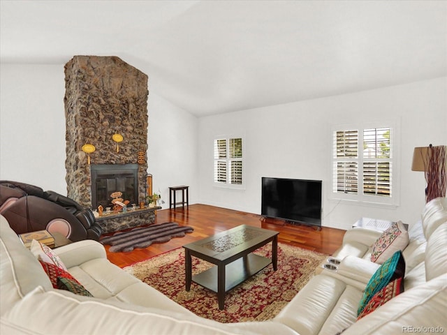 3596 S Telluride Way, Aurora, CO 80013 - living room featuring plenty of natural light, vaulted ceiling, wood finished floors, and a stone fireplace
