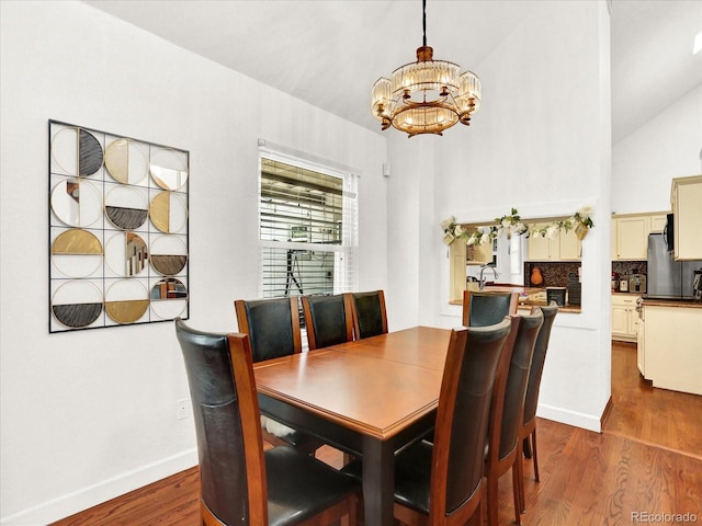 3596 S Telluride Way, Aurora, CO 80013 - dining area featuring a chandelier, dark wood finished floors, and high vaulted ceiling